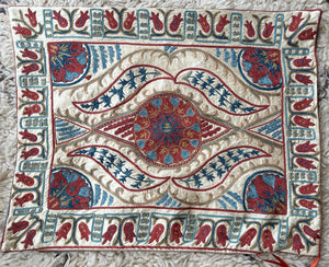 Rectangular Ottoman-style Suzani cushion with a central rosette, flowing saz leaves, and a tulip border.