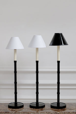 Three black and white floor lamps with different shade designs on a neutral background.