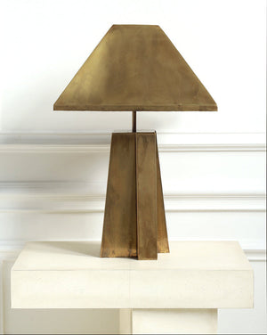 Brass table lamp on a white surface with a white wall background