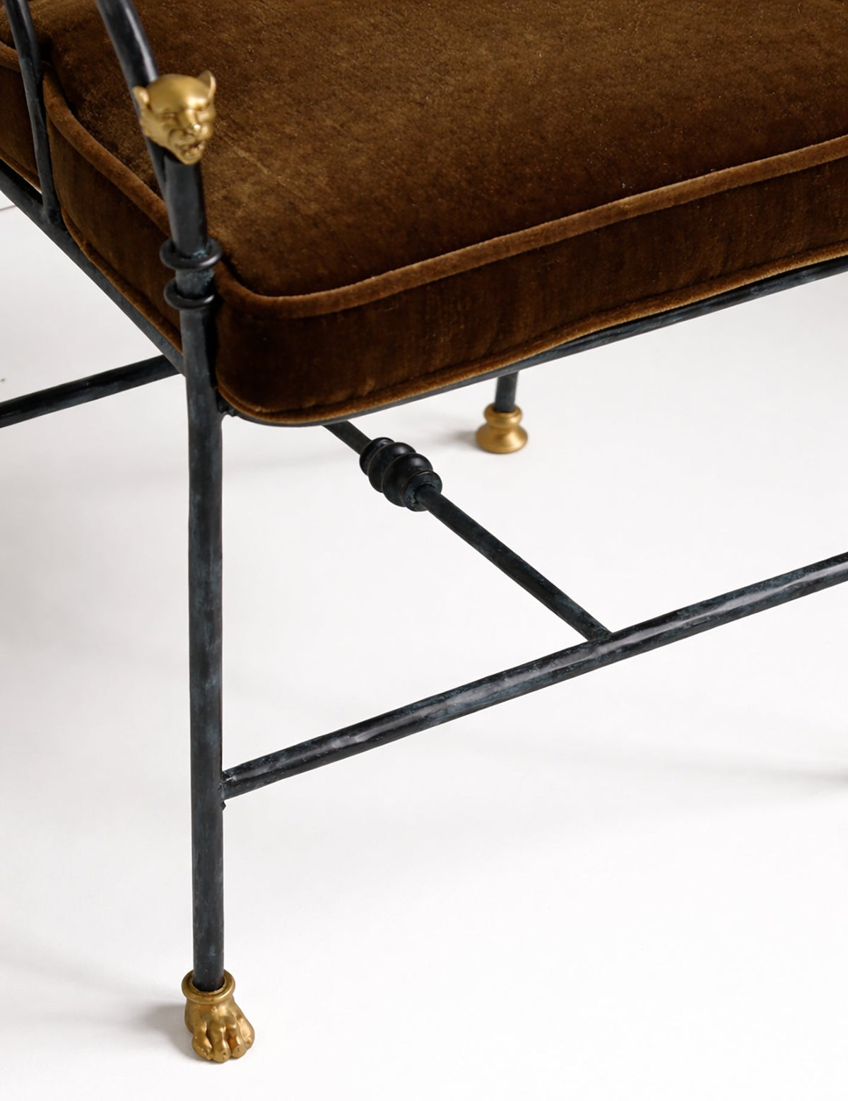 Brown cushioned chair with black metal frame and gold accents on a white background