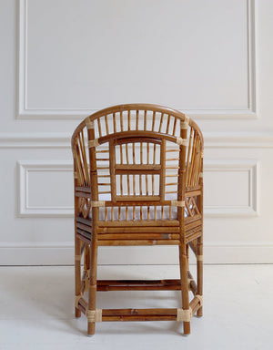 Rattan chair against a white paneled wall
