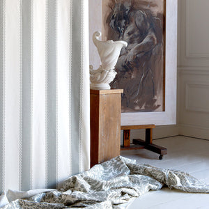 Room interior with draped fabric, sculpture, and painting on a wall.